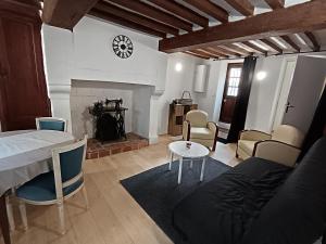 a living room with a bed and a fireplace at Le studio Aristide in Pont-Audemer