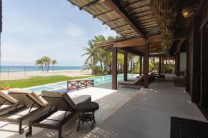 a resort patio with chairs and a swimming pool at Oceanfront Casa Rhino in Paso Hondo
