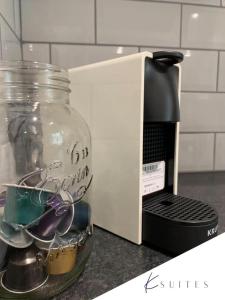 a glass jar with dishes in it next to a microwave at K Suites - The Galleria in Hatfield