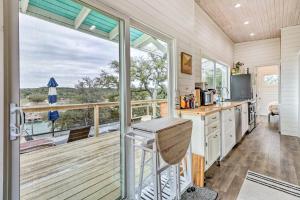a kitchen with a large window and a balcony at Updated Texas Tiny Home Rental on Lake Travis in Spicewood