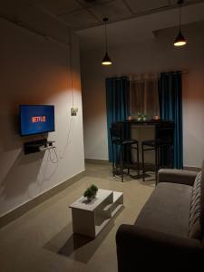 ein Wohnzimmer mit Fernseher und Tisch in der Unterkunft Zest home in Jorhat
