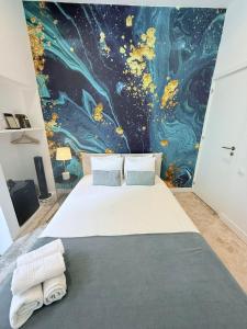 una camera da letto con un letto e un dipinto sul muro di Lisbon Studios a Lisbona Altre 66 foto