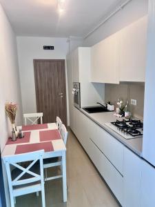 a kitchen with a table and a stove at Biby Luxury Apartament in Ploieşti +7 photos