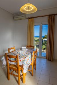 a dining room with a table and chairs and a balcony at Apartments Thekla in Karavádhos +108 photos