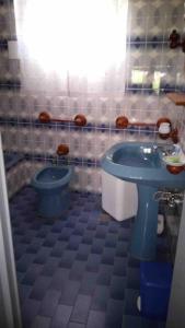 a bathroom with a blue toilet and a sink at Da Cumma' Franca in Maratea