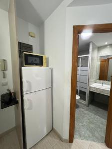 a kitchen with a refrigerator with a microwave on top of it at Residencial Alcoy in Alcoy