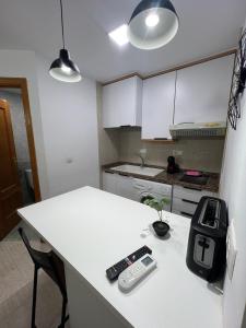a kitchen with a counter with two remote controls on it at Residencial Alcoy in Alcoy