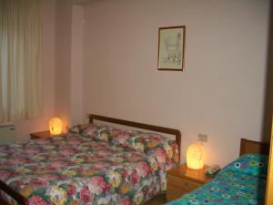 a bedroom with a bed and two lights on a table at Hotel Ristorante Fiorelli in Preci