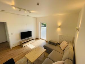 a living room with a couch and a flat screen tv at Ferienwohnung Bad Camberg - Apartment Baumwipfel in Bad Camberg