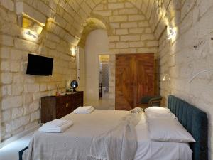 a bedroom with two beds in a stone wall at La Dimora dei Sapienti Luxury House in Melendugno +66 photos