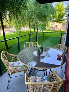 a table and chairs on a balcony with a view of a park at Biby Luxury Apartament in Ploieşti