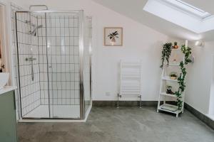 eine Dusche mit Glastür in einem Zimmer in der Unterkunft Charming Dual - Cottage A Private Modern Retreat in Llanarthney + 32 Fotos