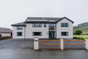 ein weißes Haus mit einem Holzzaun davor in der Unterkunft Charming Dual - Cottage A Private Modern Retreat in Llanarthney