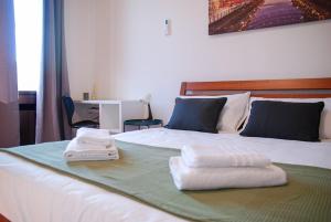 a bedroom with a bed with towels on it at Home & Pet - Tralci in Basiglio