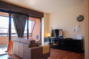 a living room with a couch and a television at Home & Pet - Tralci in Basiglio
