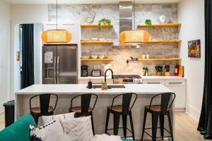 una cucina con un'isola con sedie intorno di Shimmering New NOLA Home TVs in Bedrooms & Parking a New Orleans Altre 42 foto