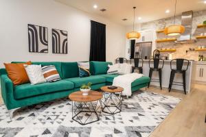 un soggiorno con un divano verde e una cucina di Shimmering New NOLA Home TVs in Bedrooms & Parking a New Orleans