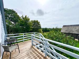 a deck with a table and chairs on a house at Lejnieki Apartment 4 in Pape