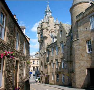 an old building with a clock tower on a street at Stylish Town Apt in Hawick