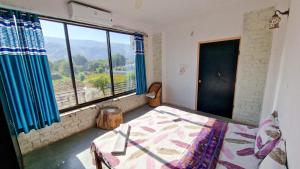 a bedroom with a bed and a large window at Café The Wall in Pushkar