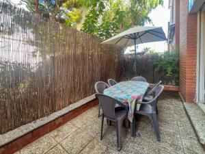 ein Tisch und Stühle mit einem Sonnenschirm auf einer Terrasse in der Unterkunft Ocean Spirit House by Hello Homes Sitges in Sitges