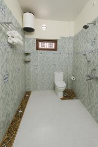 a bathroom with a toilet and a glass shower at Kashivas - 2BHK near Assi Ghat in Varanasi