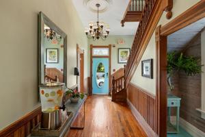 a hallway with wooden floors and a chandelier at FUENTE at Azul Mansion Key West in Key West
