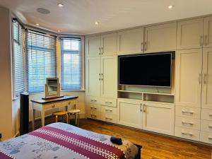 a bedroom with a bed and a desk and a television at Central London Mansion 2 in London