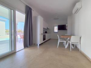 a kitchen and dining room with a table and chairs at Villa il borgo con piscina in Budoni