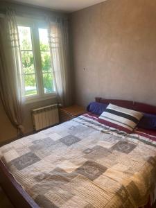 a bedroom with a large bed and two windows at Villa avec jardin et piscine 3 minutes de la Rochelle in Lagord