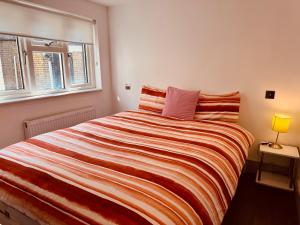 a bedroom with a large bed with a striped blanket at Central London Mansion 2 in London