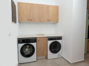 a kitchen with a washing machine and a washer and dryer at Villa Emerald in Koskinou