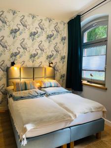 a bedroom with a bed with a dinosaur wallpaper at Korony Drzew - Apartamenty Mazury in Mrągowo