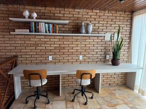 uma mesa e duas cadeiras em frente a uma parede de tijolos em Hotel Areias Belas em Maragogi mais 45 fotografias