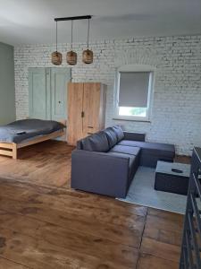 a living room with a couch and a bed at Stary Młyn in Glinik