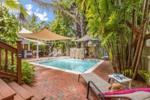 a swimming pool in a yard with palm trees at COCONUT PALM SUITE at Travelers Palm Inn Key West in Key West