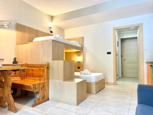 a room with a desk and a bunk bed at Hostdomus - Mughetto Apartment in Pragelato
