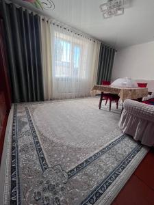 a living room with a large rug in front of a window at гостевой дом Ildan-Nurlan, horse riding in Kyzart +46 photos