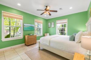 1 dormitorio con paredes verdes y 1 cama con ventilador de techo en SUGAR PALM SUITE at Travelers Palm Inn Key West, en Key West 21 fotos más