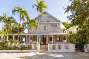 a house with palm trees in front of it at THE WHITEHEAD ROOM at Inn on Fleming Key West! in Key West