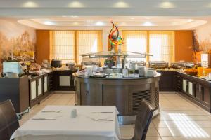 a restaurant with a kitchen with a table and chairs at Atrium Hotel Thassos in Potos