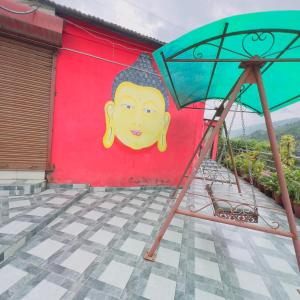 a painting of a face on a wall with an umbrella at New Pathibhara Hotel in Naubise
