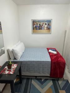 ein kleines Schlafzimmer mit einem Bett und einem Tisch in der Unterkunft Biergarten Hostel in Abraão