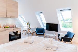 a bedroom with a bed and chairs and a kitchen at Pure Hygge in Harrislee