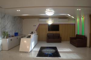 a lobby with two chairs and a television in a room at Hotel Rosa Bella in Rangpur