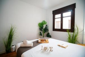a bedroom with a bed with towels and a window at Luxury Signature Apartment with FREE Parking - Malaga in Málaga +1 photo
