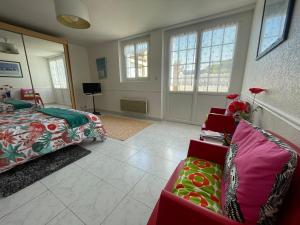 a bedroom with a bed and a couch and windows at Cosy one bedroom flat with terrace in Saint-Lunaire