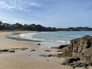 a beach with a rocky shoreline and the ocean at Cosy one bedroom flat with terrace in Saint-Lunaire +3 photos