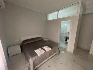 a bedroom with a bed and a large window at Zerbi House in Reggio di Calabria