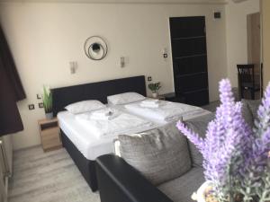 ein Hotelzimmer mit einem Bett und einer Couch in der Unterkunft Wellness Hotel TREZOR in Pécs